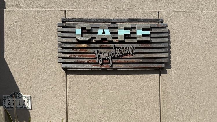The wooden Café Bagelicious sign on the wall at 2713 E Main St, Ventura